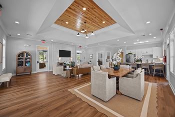 A spacious living room with a wooden ceiling and a large rug on the floor at Regency Townes in Greenville, NC